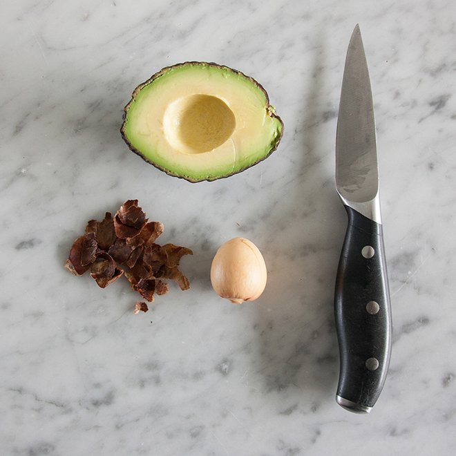 Peeling off an avocado pit with a knife, by Botanopia