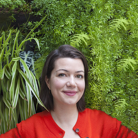 portrait of Botanopia founder in front of a plant wall
