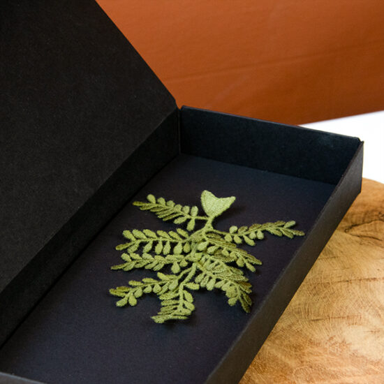Olive branch embroidered brooch close up in packaging box